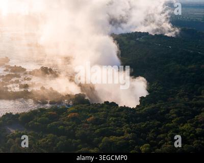 Die nebelige Wolke der Victoria Falls über dem Sambesi River bei Sonnenuntergang Stockfoto