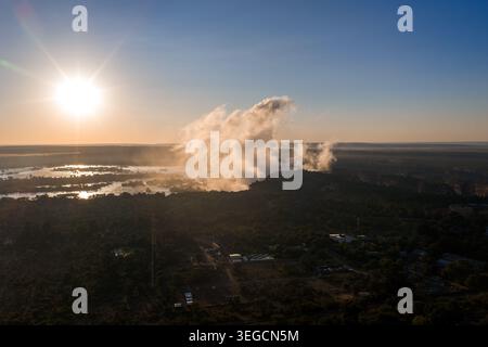 Blick auf den Sonnenuntergang von Victoria Falls über dem Zambezi River Stockfoto