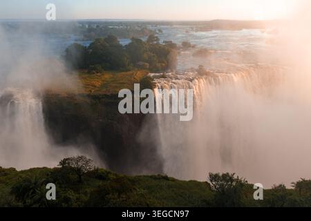 Sonnenuntergang über den Victoria Falls mit dem Zambezi River und Nebel aus der Luft Stockfoto