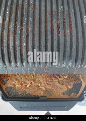 Dreckiger Grill nach dem Kochen von Fleisch. In braunem Fett grillen. Schmutziges Geschirr. Stockfoto
