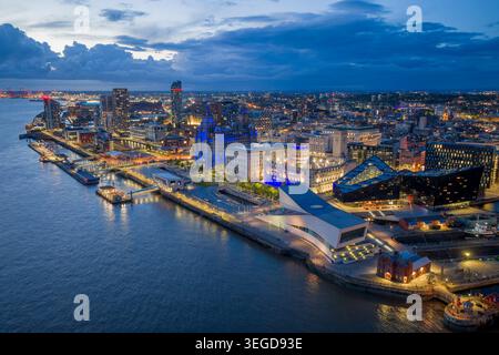 Liverpool-Wasserfront bei Nacht mit dem beleuchteten Royal Liver Building, Pier Head und der Skyline der River Mersey in Merseyside, England. Stockfoto