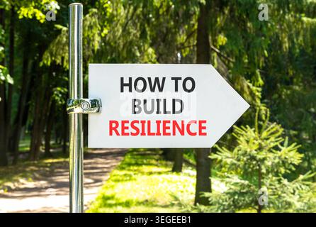 So erstellen Sie ein Resilienzsymbol. Konzeptworte wie man Widerstandsfähigkeit auf einem schönen weißen Straßenschild schafft. Schöner grüner Garten im Hintergrund. Geschäftsanweisungen Stockfoto