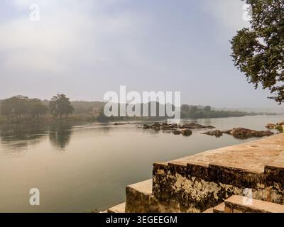 Orchha, Indien, 22.02.20. Ein ruhiger Blick auf den Betwa River mit großen Granitfelsen und nebligen, bewaldeten Ufern in Orchha, Madhya Pradesh. Stockfoto