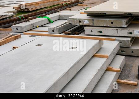 Betonfertigteilplatten und Stahlbauplatten auf der Baustelle für moderne Gebäude gestapelt Stockfoto