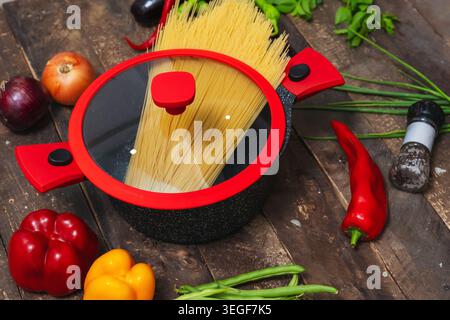 Frische Zutaten Für Traditionelle Pasta. Kochszene Mit Lebhaftem Gemüse Und Pasta Stockfoto