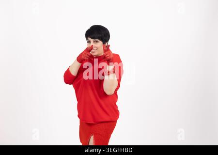 Junge, stilvolle Frau, die in rotem Outfit über die Schulter schaut Stockfoto