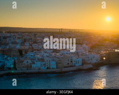 Panoramablick der Drohne auf die Altstadt von Monopoli bei Sonnenuntergang, malerische Adria-Küstenstadt in Apulien mit historischer italienischer Architektur Stockfoto