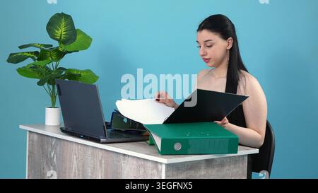 Konzentrierte Geschäftsfrau, die Berichte am Schreibtisch liest Stockfoto