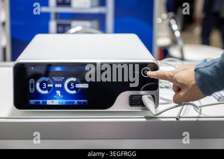 Ein-/Ausschalter für Dentalgeräte in Nahaufnahme. Nahaufnahme einer Hand, die an einem modernen Zahnbehandlungsgerät mit Touchscreen-Bedienelementen in der Klinik dreht. Stockfoto