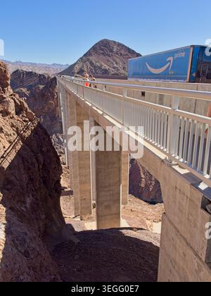 Touristen mit Blick über die Hoover Dam Bypass Bridge mit vorbeifahrendem Traktoranhänger – Boulder City, Nevada, 2. November 2025 Stockfoto