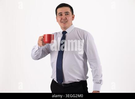 Selbstbewusster Geschäftsmann mit roter Kaffeetasse und lächelndem Kamerastudio Stockfoto