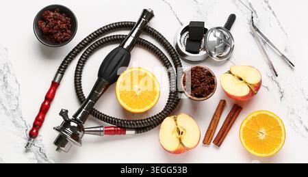 Teile von Shisha, Tabak, Obst und Zimt auf Marmorhintergrund Stockfoto