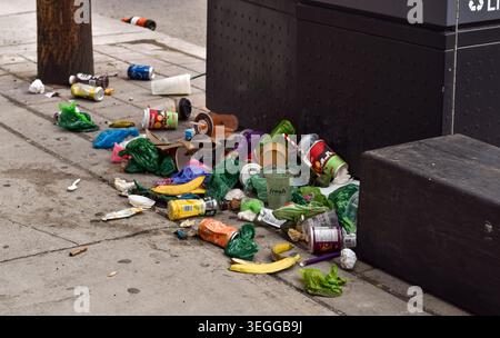Toronto, Ontario, Kanada - 17. Mai 2026: Überlaufender Müllhaufen auf dem Bürgersteig neben einem ausgewiesenen Abfallcontainer in der Innenstadt Stockfoto