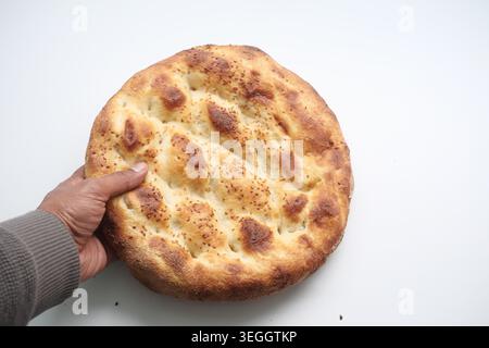 Frisch gebackenes Brot wird von einer Person in der Küche gehalten Stockfoto
