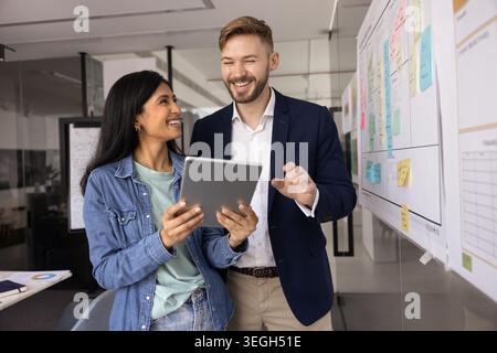 Teamkollegen lachen, genießen Sie gemeinsame Diskussionen mit Tablet-PCs Stockfoto