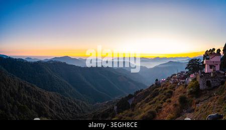 Ein großer Panoramablick auf die Himalaya-Bergkette während eines goldenen Sonnenaufgangs mit einem kleinen Dorf auf dem Hügel in Chakrata, Uttarakhand, I Stockfoto