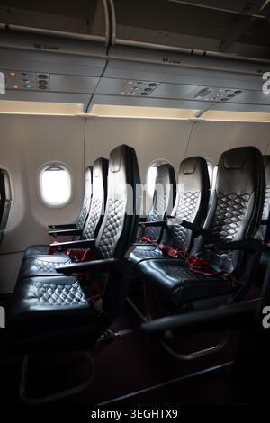 Leere Passagiersitze in der Kabine. Verlassene Sitzreihen in der Economy Class. Stockfoto