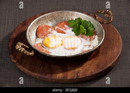 Gebratene Eier zum Servieren in einer Pfanne, frische Sunny-Side-Up-Eier mit goldenen Eigelb, zubereitet für das Frühstück und traditionelle Hausmannskost Stockfoto