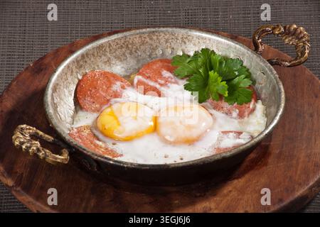 Gebratene Eier zum Servieren in einer Pfanne, frische Sunny-Side-Up-Eier mit goldenen Eigelb, zubereitet für das Frühstück und traditionelle Hausmannskost Stockfoto