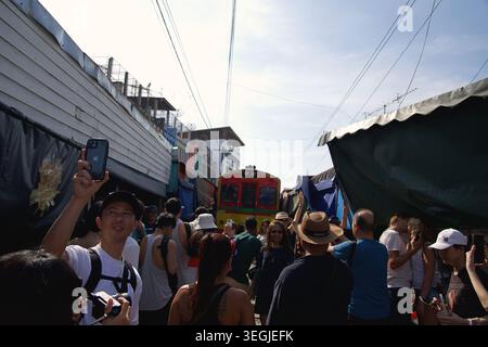 Der Zug fährt durch den Maeklong Railway Market, Thailand. Berühmter Eisenbahnmarkt in Samut Songkhram, 2024, 31. Dezember Stockfoto