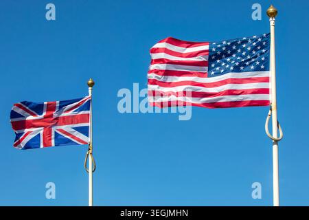 Fahnen des Vereinigten Königreichs und der Vereinigten Staaten von Amerika fliegen zusammen – nationale Symbole zweier Verbündeter. Stockfoto