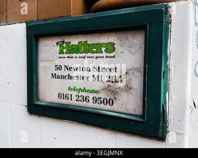 Manchester, UK - 01. Mai 2026: Das verwitterte, gerahmte Hatters-Schild mit der Adresse und Telefonnummer von 50 Newton Street in Manchester, UK. Stockfoto