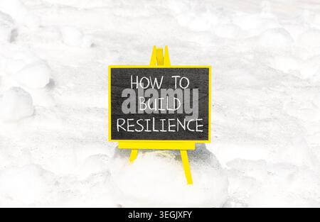 So erstellen Sie ein Resilienzsymbol. Konzeptworte wie man Widerstandsfähigkeit auf schönen Tafeln schafft. Schöner weißer Schnee Hintergrund. Business wie man baut Stockfoto
