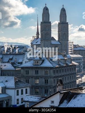 Nahaufnahme der Türme des Großmunster Doms und historischer Gebäude mit Schnee auf den Dächern in Zürich Stockfoto