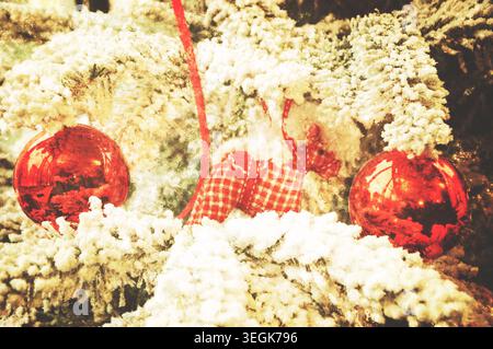 Vintage-Weihnachtsdekoration hängt an einem mit Schnee bedeckten Weihnachtsbaum. Vintage-Weihnachtskarte. Selektiver Fokus. Getöntes Foto mit Kratzern. Stockfoto