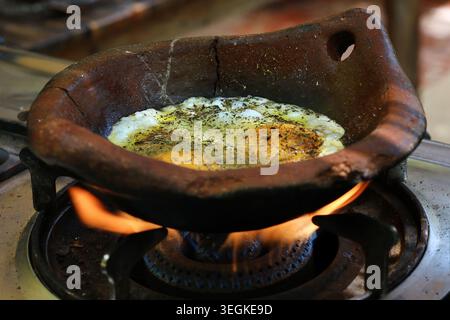 Eier in einer traditionellen Terrakotta-Pfanne als Teil eines typischen rustikalen Frühstücks im Libanon gebraten. Stockfoto
