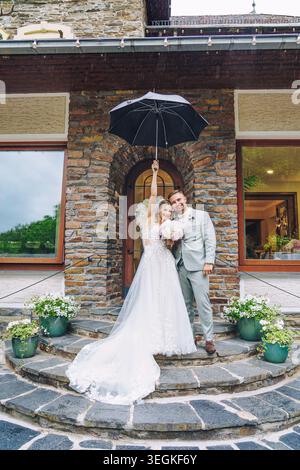 Hochzeit - wunderschöne Braut und Bräutigam unter dem Regen Stockfoto