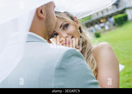 Wunderschönes Brautpaar, das an ihrem Hochzeitstag kuschelt Stockfoto