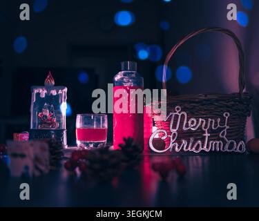 Moody Christmas still Life mit festlichen Lichtern und Gläsern hausgemachten Rotweins auf dunklem Hintergrund Stockfoto