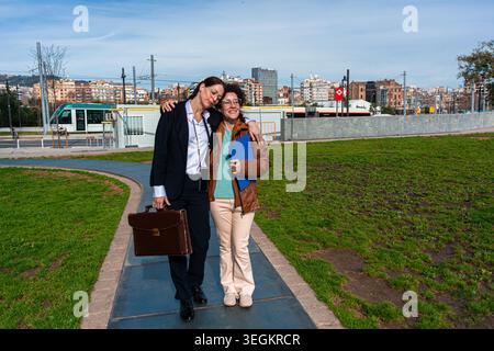 Professionelle Geschäftsfrauen, die gemeinsam auf einem urbanen Parkweg laufen Stockfoto