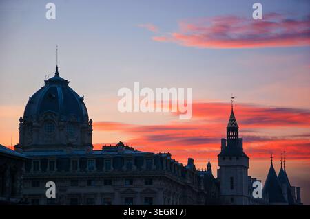 Conciergerie und Tribunal of Commerce in Paris in der Abenddämmerung mit gotischen Türmen, die sich vor dem Sonnenuntergang abzeichnen, Frankreich Stockfoto