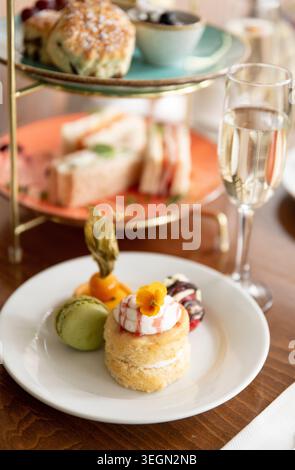 Köstlicher Nachmittagstee mit Gebäck, Macarons und Champagner in gemütlicher Umgebung Stockfoto