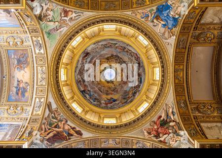 Sehen Sie majestätische Fresken, die die Deckenkuppel und die umliegenden Wände im Inneren der historischen Basilika in Rom schmücken Stockfoto
