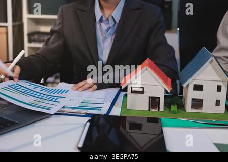 Asiatische Frauen führen eine junge Gruppe multiethnischer Geschäftsleute in Teambesprechungen mit Laptop-Computer für ESG-Themenpräsentationen auf dem Monitor. Nachhaltig b Stockfoto
