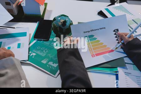 Asiatische Frauen führen eine junge Gruppe multiethnischer Geschäftsleute in Teambesprechungen mit Laptop-Computer für ESG-Themenpräsentationen auf dem Monitor. Nachhaltig b Stockfoto