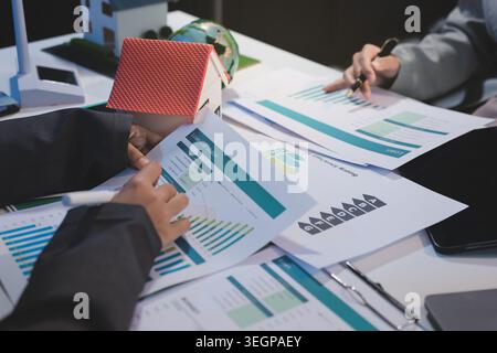Asiatische Frauen führen eine junge Gruppe multiethnischer Geschäftsleute in Teambesprechungen mit Laptop-Computer für ESG-Themenpräsentationen auf dem Monitor. Nachhaltig b Stockfoto