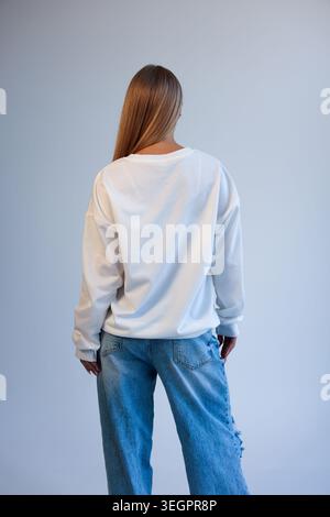 Frau in lässiger Stadtkleidung. Weibliche Figur von hinten in einem bequemen, von der Stadt inspirierten Outfit Stockfoto