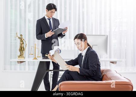 Zwei Anwälte in einem modernen Büro, die Dokumente an einem Schreibtisch überprüfen. Stockfoto