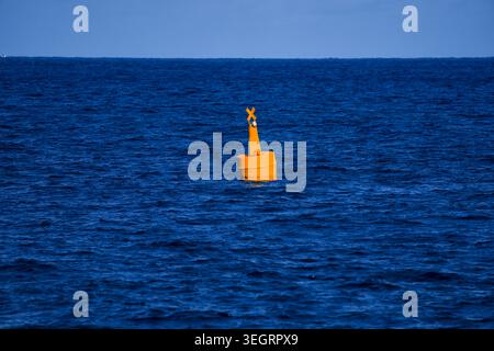 Gelbe maritime Boje, die auf tiefblauem Meer schwimmt Stockfoto