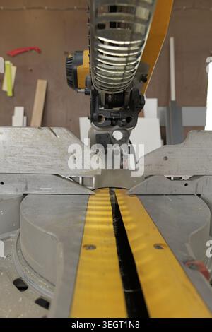 Präzisionsschneidewerkzeug, eine Gehrungssäge, in einer professionellen Werkstatt, bereit für Holzbearbeitung, Tischlerei und Bauprojekte mit Schwerpunkt auf craf Stockfoto