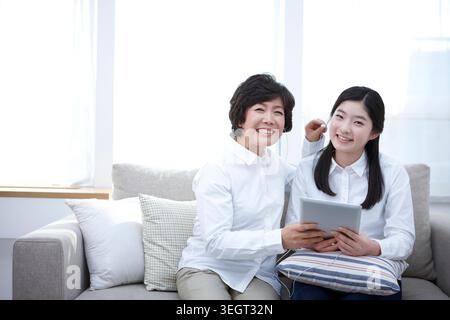Mutter und Tochter mit tablet-PC zusammen auf einer couch Stockfoto