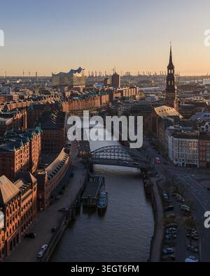 Blick aus der Vogelperspektive auf die Speicherstadt mit historischen Backsteinhäusern, die Elbphilharmonie und die Katharinenkirche bei Sonnenuntergang in Hamburg, Hambur Stockfoto