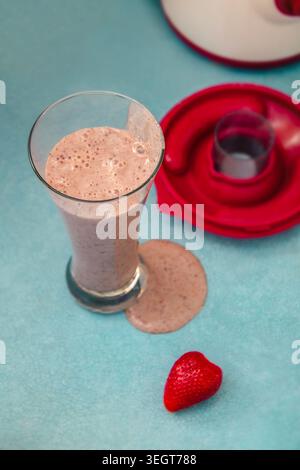 Erdbeeren-Milchshake in einem hohen Glas auf der Küchenzeile Stockfoto