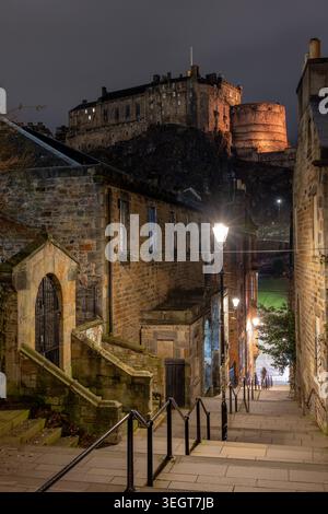 Das Vennel bei Nacht mit Blick auf das beleuchtete Schloss Edinburgh in der historischen Altstadt von Edinburgh, Schottland. Stockfoto