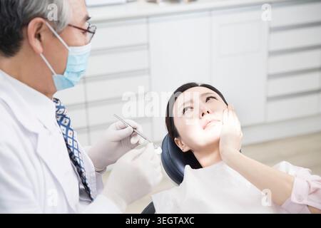Oberzahnarzt und Zahnschmerz-Patientin Stockfoto