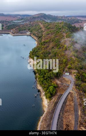 Vertikale Luftaufnahme des Glenbawn Dam und der umliegenden Berglandschaft mit Morgennebel in NSW Australien. Das Drohnenfoto fängt den Damm ein Stockfoto